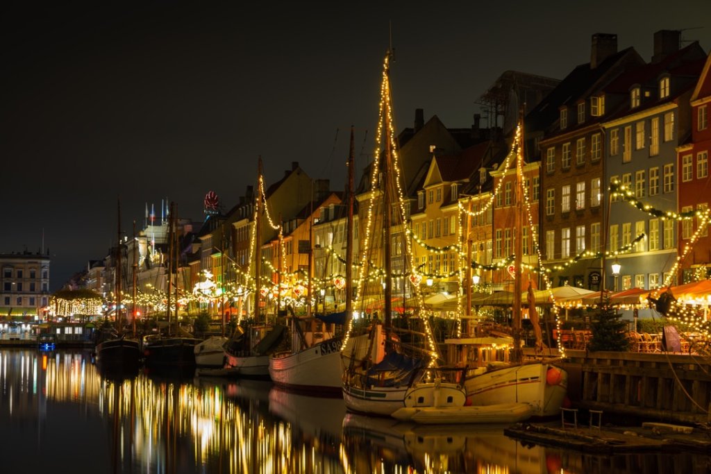 Boats and row houses on Copenhagen canal decorated with Christmas lights