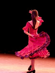 Spanish flamenco dancer twirling in traditional red dress