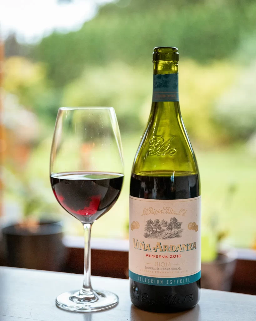 Bottle of red wine with a full glass of red wine next to it