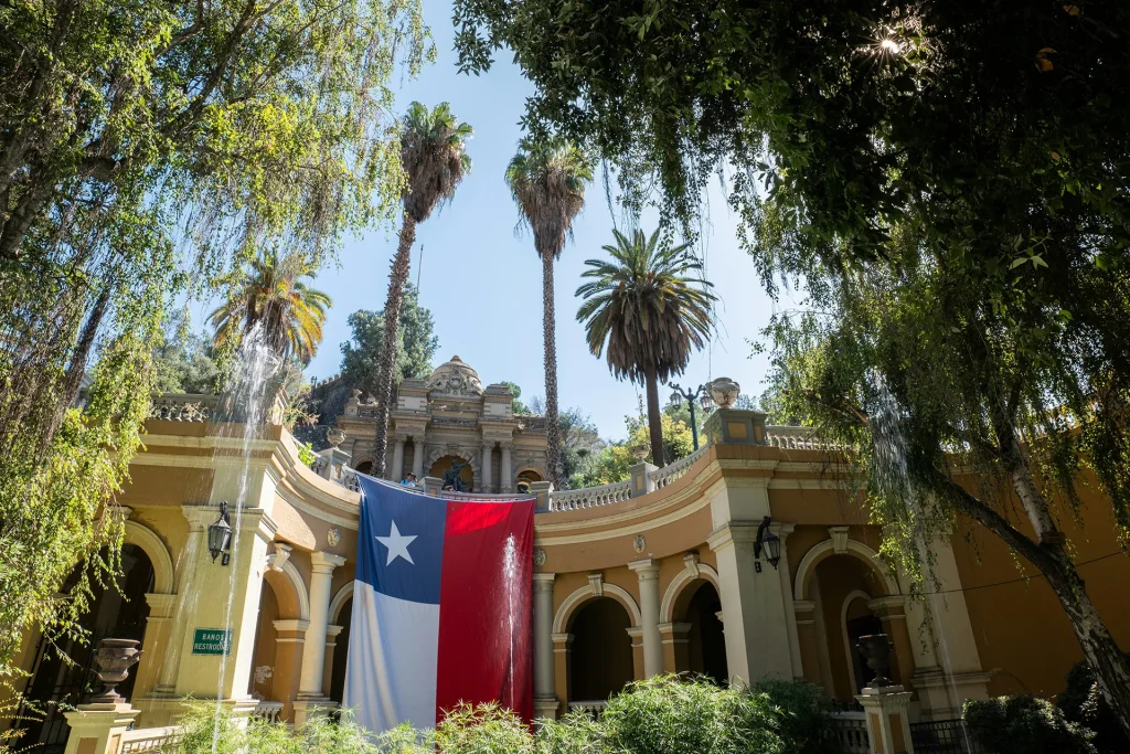 Chilean flag on historical building with tall palm trees in the background in Santiago, Chile